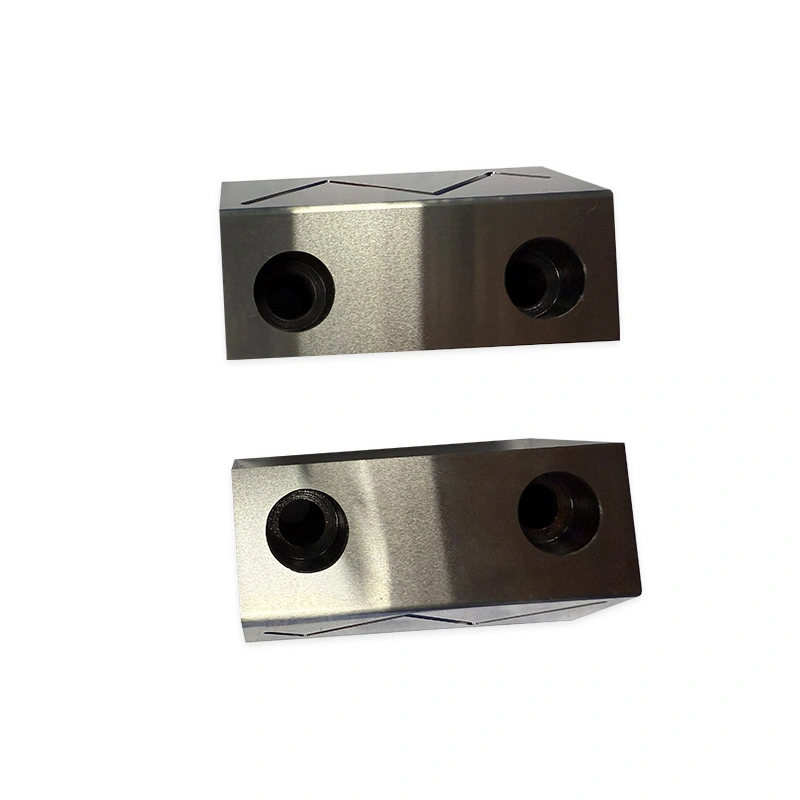 Two rectangular machined metal blocks with large circular bores and angled grooves